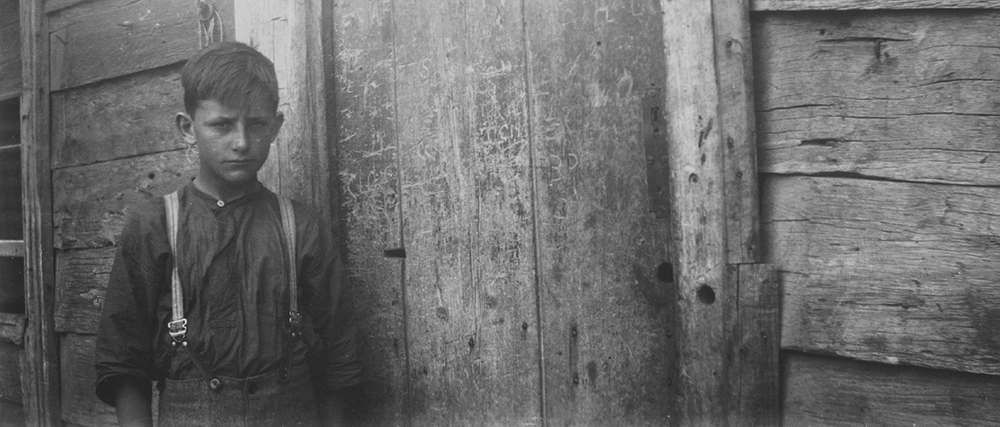 Back door of the Kelly homestead, Eleven Mile Creek, Glenrowan West. Photo: Leo P. Ryan From Max's notes: The slab back door of the Kelly home is covered with carved initials. They include K.K., A.S., J.B., N.K., D.K., S.H., and all said to have been carved by Kate, Sherritt, Joe Byrne, Dan & Ned and Steve Hart themselves. The cuts certainly looked old when I saw them. The boy is Ned’s nephew ( - Griffiths) and the similarity of his expression to the photos of Ned and his brother, and to that of Jim Kelly is remarkable. There was a definite likeness of expression in the Kelly family.